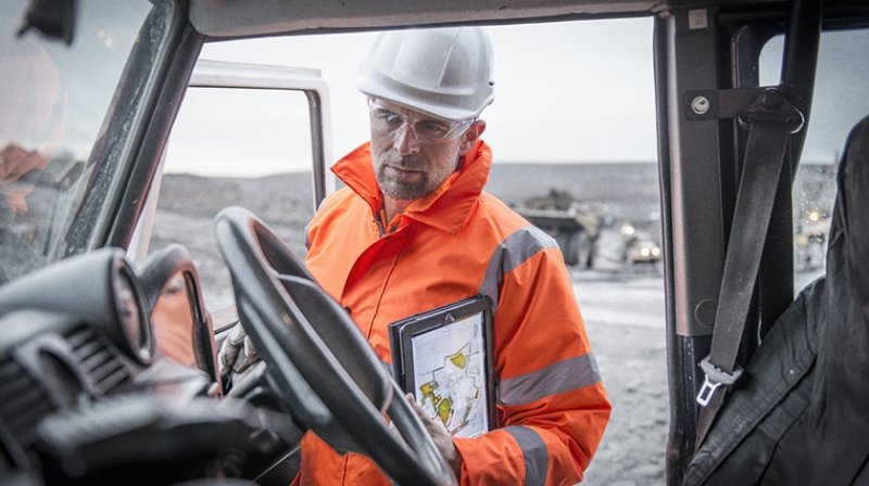 矿工与安全帽和防护设备检查平板卡车